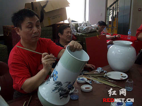 著名花鳥(niǎo)畫(huà)家王國(guó)勛在現(xiàn)場(chǎng)繪制陶瓷藝術(shù)品。