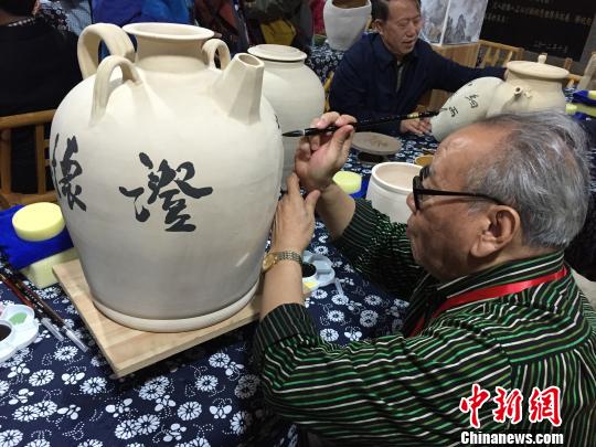 書法名家在陶瓷收藏壺上進(jìn)行創(chuàng)作。 李俊杰 攝
