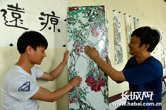 向人展示自己的作品瓷版《碩果累累》。陳儒 攝